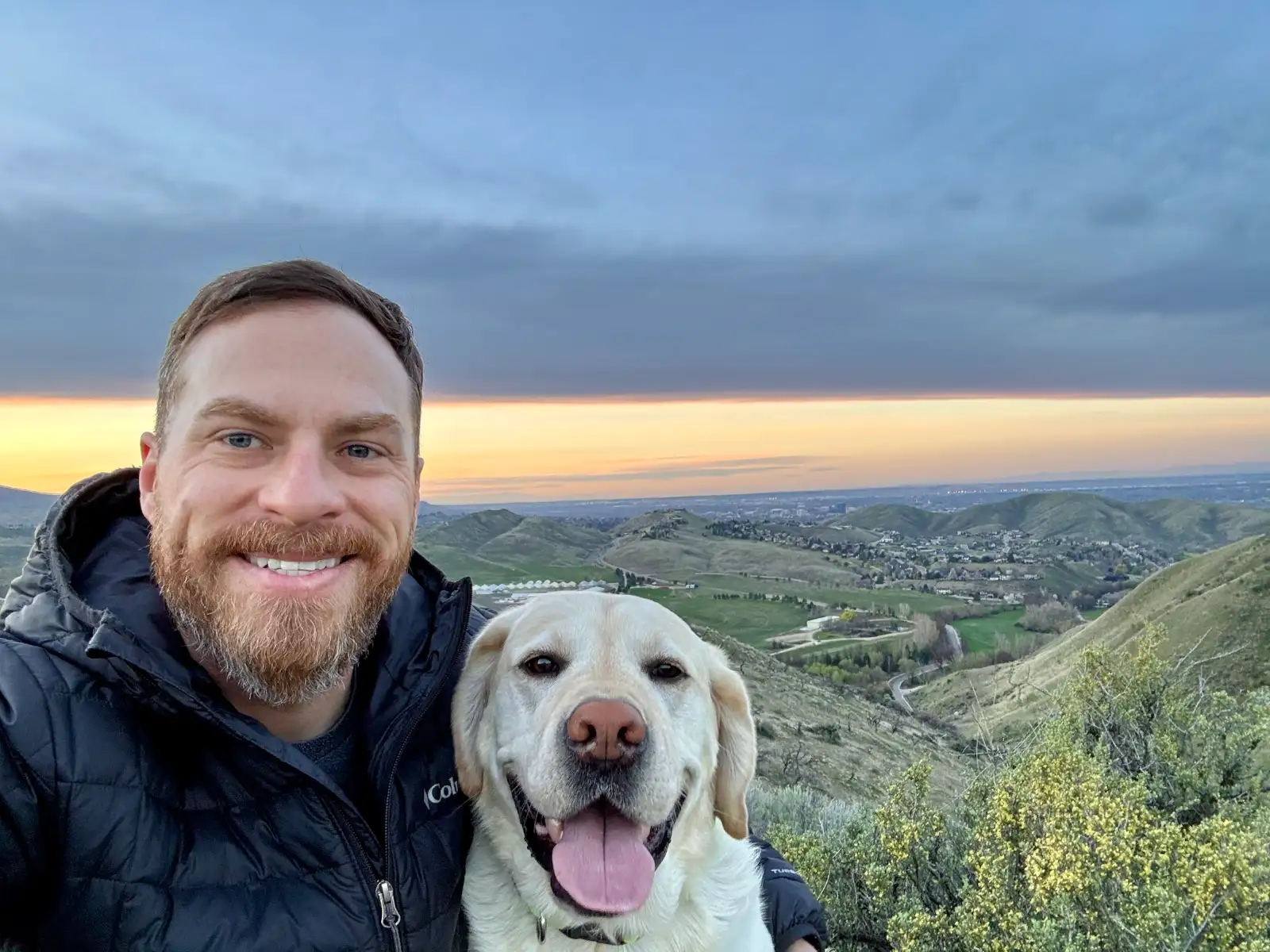 Travis Arn with his Labrador, Baxter, overlooking the Boise foothills.